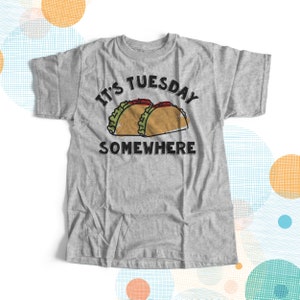 May include: Gray t-shirt with the text "It's Tuesday Somewhere" and a cartoon image of two tacos.