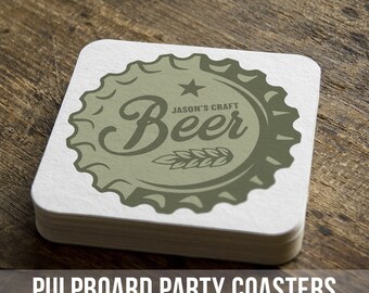 May include: A stack of white square pulpboard coasters with a green beer bottle cap design. The design features the word "Beer" in a stylized font with a star and the text "Jason's Craft".