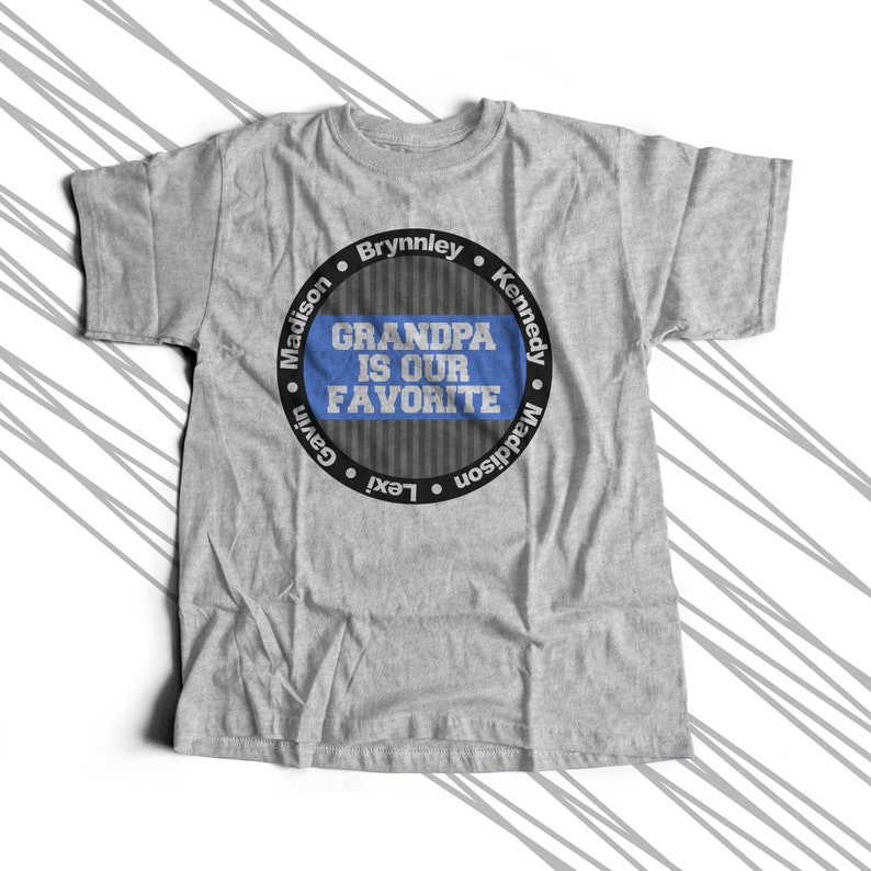 Puede incluir: Camiseta gris con un dise&ntilde;o circular negro que dice "Grandpa is our favorite" con los nombres Madison, Gavin, Lexi, Brynnley, Kennedy y Maddison alrededor del c&iacute;rculo.