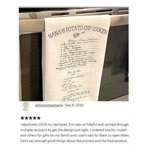 May include: A white tea towel featuring a printed recipe titled Nana's Potato Chip Cookies. The design includes a whisk illustration and handwritten-style text detailing ingredients and baking instructions, hanging over a stainless steel oven handle.