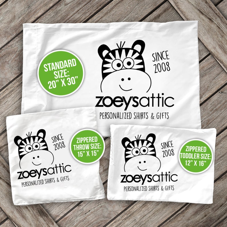 May include: Three white pillowcases with black and white zebra print designs. Each pillowcase has a green circle with text that says "zoeysattic" and "personalized shirts & gifts". The pillowcases are available in three sizes: standard (20" x 30"), throw (15" x 15"), and toddler (12" x 16").