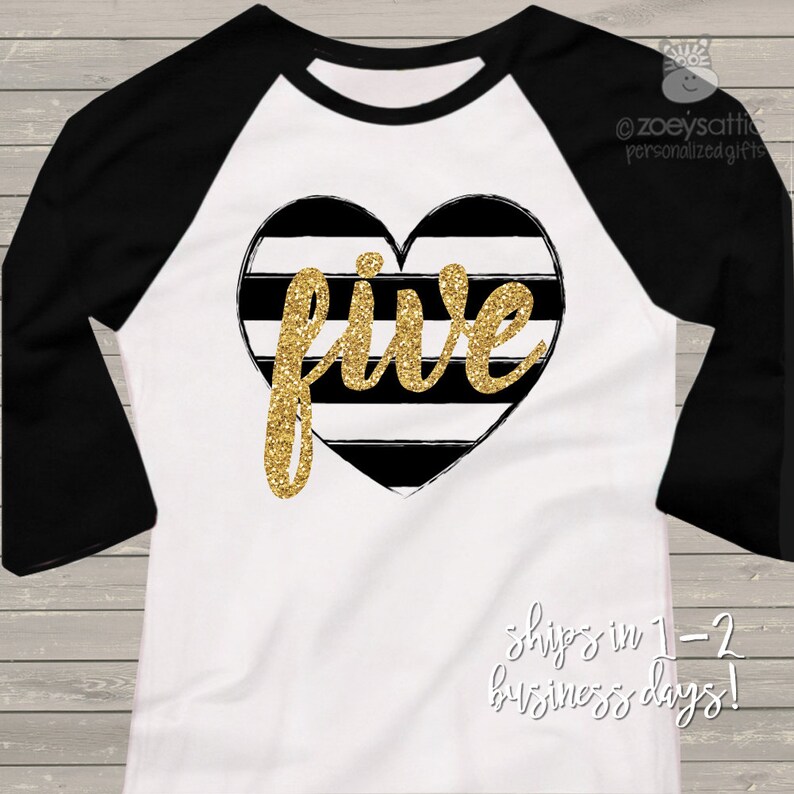 May include: White and black raglan shirt with black sleeves. The shirt features a heart-shaped design with black and white stripes and the word "five" in gold glitter. A birthday-themed shirt.