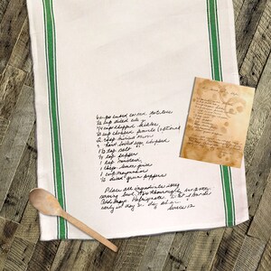 May include: A white tea towel with green stripes and handwritten instructions for a potato salad recipe. The recipe includes ingredients like cooked potatoes, celery, pickles, mayonnaise, mustard, and lemon juice. The text also includes instructions to mix the ingredients thoroughly and refrigerate before serving.
