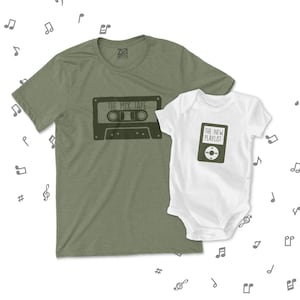 May include: A green t-shirt with the text "The Mix Tape" and a cassette tape graphic. A white baby onesie with the text "The New Playlist" and a music player graphic.