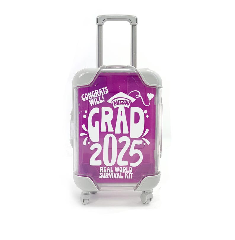 May include: A small pink suitcase with a white handle and wheels. The suitcase has a white sticker that says "Congrats Will! Mizzou Grad 2025 Real World Survival Kit".