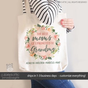 May include: A white tote bag with a floral wreath design and the text "The Best Moms Get Promoted to Grandma". The names "Adalyn, Holden, Marcus, and Maf" are listed below the wreath.