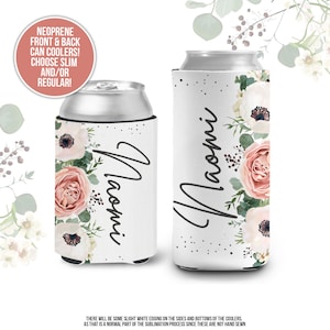 May include: Two white neoprene can coolers with a floral design and the name "Naomi" written in black script. The flowers are pink, white, and green.