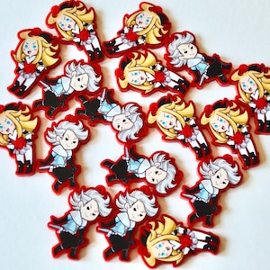 May include: A collection of 17 colourful, cartoon-style character charms. Each charm features a different character with a unique expression and pose. The charms are made of a red, white and black colour scheme.