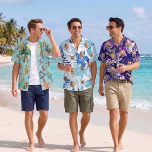 Può includere: Tre camicie a maniche corte con bottoni e stampe fotografiche personalizzate. La prima è azzurra con palme e stelle marine, la seconda è bianca con foglie tropicali blu e facce di gatto, la terza è viola scuro con motivi floreali.