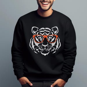 May include: Black sweatshirt with a white tiger wearing orange glasses graphic print.