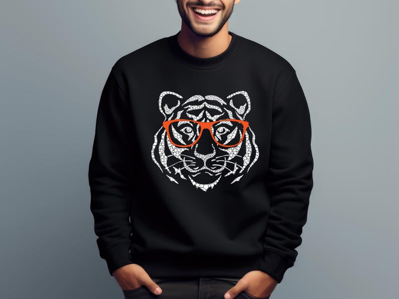 May include: Black sweatshirt with a white tiger wearing orange glasses graphic print.