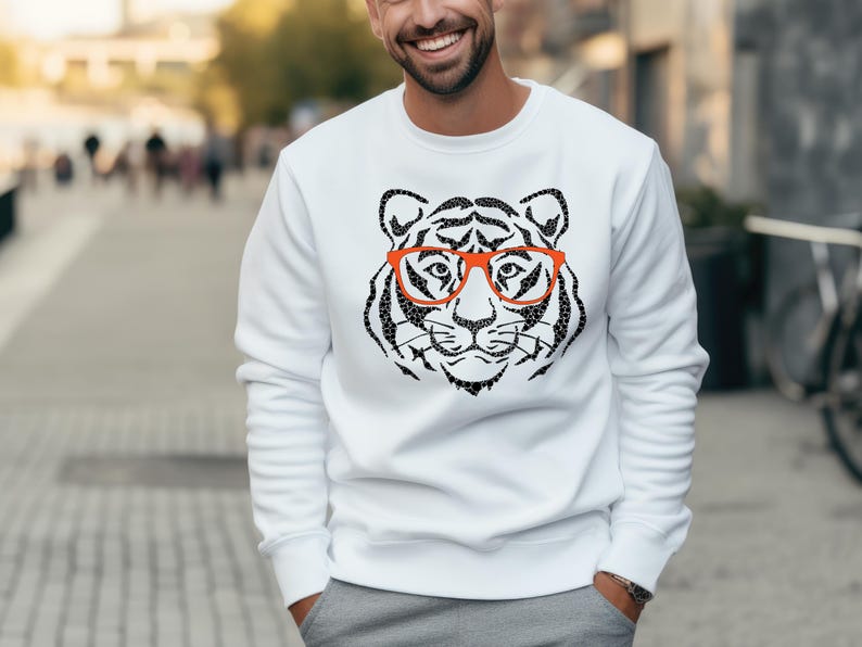 May include: White sweatshirt featuring a black and white tiger wearing red glasses graphic print.