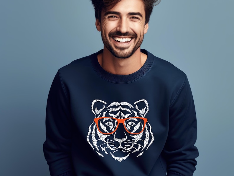 May include: A navy blue sweatshirt featuring a white graphic of a tiger wearing red-rimmed glasses.