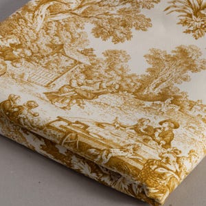Pode incluir: Tecido dobrado com um padrão toile de Jouy dourado e creme. O padrão mostra uma cena pastoral detalhada com figuras, árvores e edifícios. O tecido está dobrado, revelando a repetição do padrão.