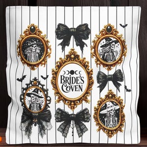 May include: White tote bag with black vertical stripes, featuring gold-framed illustrations of skeletons in witch hats and black bows. The text "Bride's Coven" is displayed. A carved pumpkin and Halloween decorations are in the background.