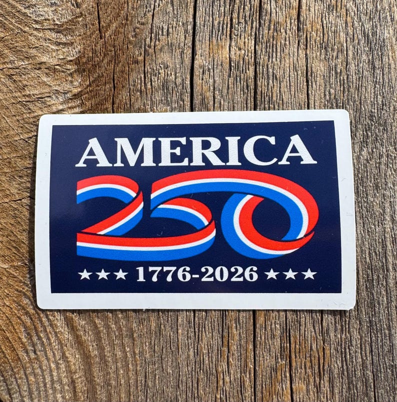 May include: A rectangular sticker with a navy blue background and white border. The word "AMERICA" is at the top in white capital letters. Below, the number "250" is stylized with red, white, and blue ribbons. The text "1776-2026" is at the bottom, with stars.