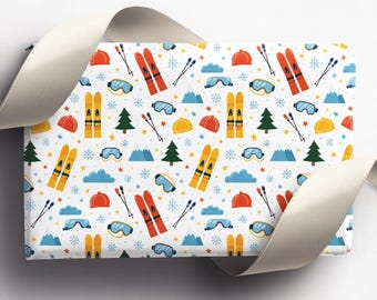 May include: White wrapping paper with a repeating pattern of winter sports equipment. The design includes orange and yellow skis, red skis, blue goggles, orange and yellow helmets, green trees, blue mountains, and snowflakes.
