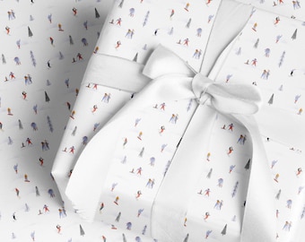 Peut inclure: Papier cadeau blanc avec un motif répétitif de personnes skiant et faisant du snowboard dans un paysage d'hiver. Le papier est enveloppé autour d'une boîte cadeau avec un ruban blanc.