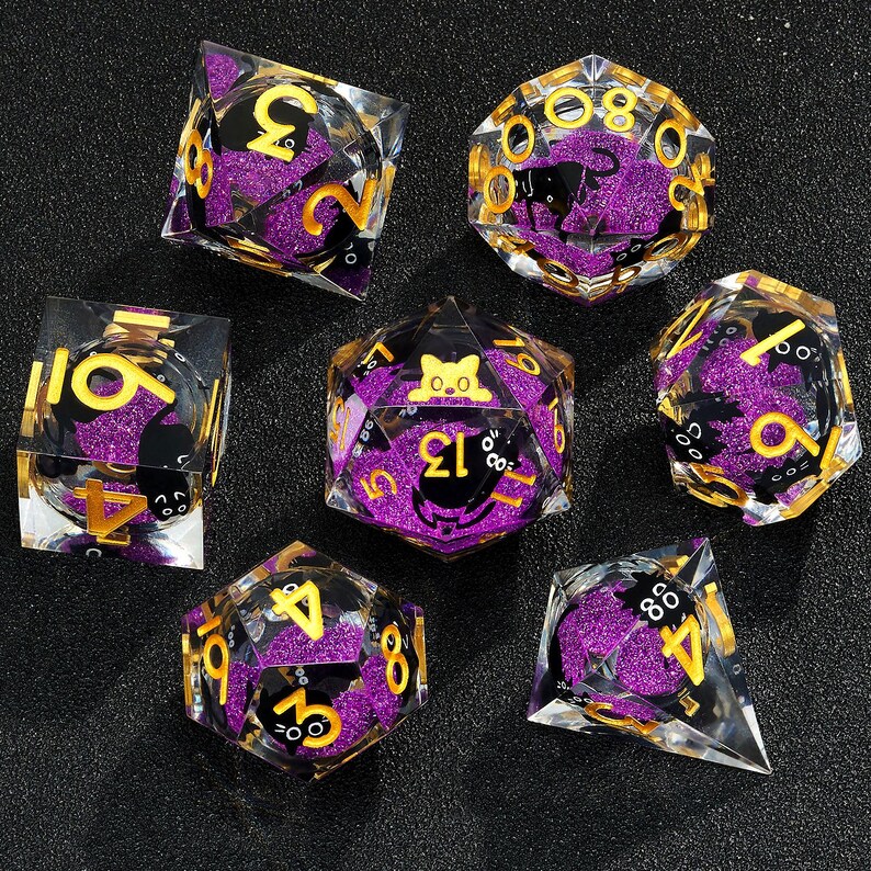 May include: Set of seven purple and gold dice with black cat and number designs. The dice are made of clear plastic with glitter embedded in the plastic.