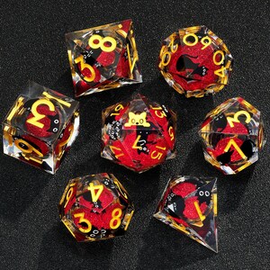 May include: Set of ten red and gold dice with black cat and other animal illustrations. The dice are made of clear resin with a red and gold glitter fill.