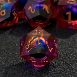 May include: A set of six iridescent purple and red dice with gold numbers. The dice are made of clear resin with a swirling pattern inside. The dice are numbered 1 through 6.