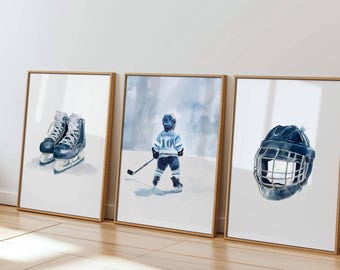 May include: Three framed wall art prints featuring ice hockey themes. The left print shows a pair of dark blue ice skates. The center print depicts a hockey player wearing a light blue jersey with the number 10. The right print shows a dark blue helmet.