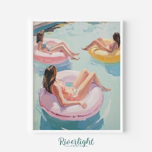May include: A framed art print depicts three people relaxing in a pool on inflatable rings. The artwork features a light color palette with pink, yellow, and blue hues. The print is signed "Riverlight Prints" at the bottom.