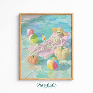 May include: A framed art print featuring a skeleton wearing a straw hat, lounging on a pink pool float in blue water. The scene includes a cocktail, two pumpkins, and three colorful beach balls. The text Riverlight Prints appears at the bottom.