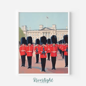 May include: A framed print of the Buckingham Palace guards in their iconic red coats and tall black hats. The guards stand in formation in front of the palace, with a blue sky and a flag waving in the background. The print is labeled "Riverlight Prints".