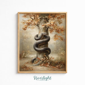 May include: A framed wall art print featuring a dark, coiled snake wrapped around the trunk of a tree with autumn foliage. The scene is set in a forest with fallen leaves on the ground and soft, muted tones. The text Riverlight PRINTS is at the bottom.