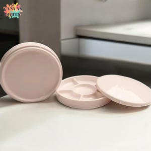 Könnte beinhalten: Ein Set aus drei rosafarbenen Keramik-Farbpaletten mit Deckel. Die Palette hat fünf separate Vertiefungen zum Mischen von Farbe.