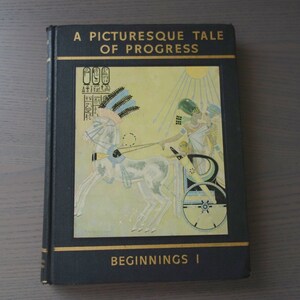 May include: A black book with gold lettering titled "A Picturesque Tale of Progress" with an illustration of a chariot pulled by a white horse and a person in a chariot. The book also has the text "Beginnings I" on the bottom.