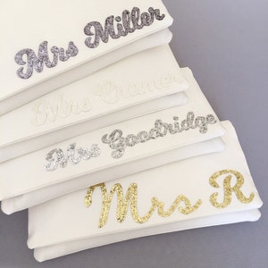 Ivory satin MRS bridal clutch for wedding day.  It can be personalised with the brides new surname or initial, made from grey, ivory, silver and gold glitter.