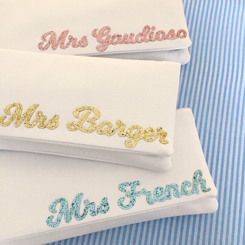 Ivory satin MRS bridal clutch for wedding day.  It can be personalised with the brides new surname, made from rose gold, gold and light blue glitter.