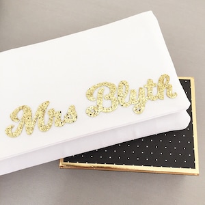 Ivory satin MRS bridal clutch for wedding day.  It can be personalised with the brides new surname, made from gold glitter.