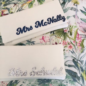 Ivory satin MRS bridal clutch for wedding day.  It can be personalised with the brides new surname, made from navy and silver glitter.