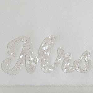 Close up detail of ivory satin MRS bridal clutch for wedding day.  It can be personalised with the brides new surname, made from ivory glitter.