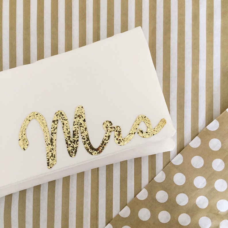 Ivory satin bridal clutch for wedding day.  The design on the front says MRS which is made from gold glitter.