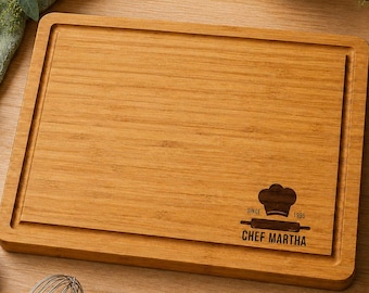 May include: A rectangular bamboo cutting board with a juice groove along the perimeter. The board features a laser-engraved design in the bottom right corner showing a chef hat, a rolling pin, the text "SINCE 1995", and "CHEF MARTHA".