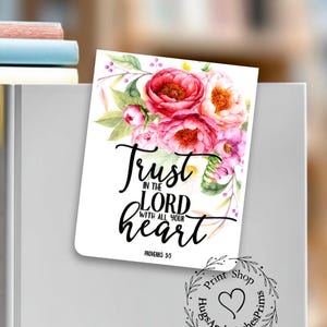May include: A rectangular magnetic bookmark featuring a watercolor floral illustration of pink and red peonies with green leaves. The text reads Trust in the LORD with all your heart Proverbs 3:5. A circular logo with a heart is also visible.