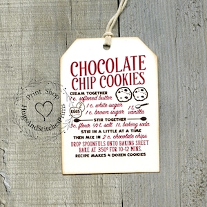 May include: A white recipe card with red text for chocolate chip cookies. The recipe includes ingredients like softened butter, white sugar, brown sugar, vanilla, flour, salt, baking soda, and chocolate chips. The recipe makes 4 dozen cookies.