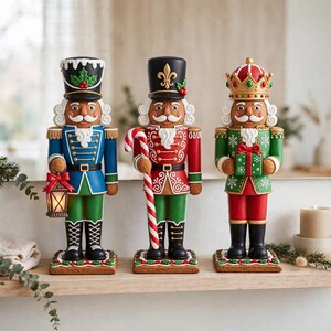 May include: Three decorative nutcracker figurines designed to resemble gingerbread cookies. The left figure holds a lantern, the centre figure holds a candy cane, and the right figure holds a gift box. Each stands on a square base with icing details.