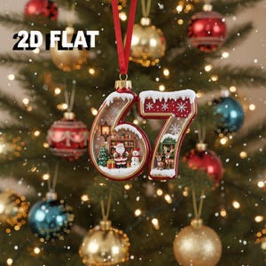 May include: A Christmas ornament shaped like the number 67, with a red border and white snow accents. The interior of the 6 features Santa Claus, a Christmas tree, and a snowman. The 7 has reindeer. The ornament hangs from a red ribbon.