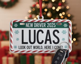Può includere: Un ornamento natalizio personalizzato a forma di targa con il nome "LUCAS" in nero. Recita "NEW DRIVER 2025" e "LOOK OUT WORLD, HERE I COME!" con dettagli a fiocco di neve. Un portachiavi per auto è appeso sotto.