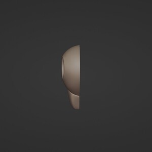 May include: A side view of a light brown, rounded object with a circular opening. The object has a smooth surface and a curved shape, possibly a part of a larger design or product. The background is a solid, dark gray color.