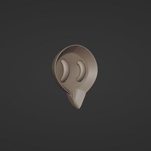 May include: A brown, teardrop-shaped object with two curved, oblong cutouts near the top. The bottom of the object tapers to a point. The object is set against a dark gray background.