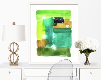 Op de afbeelding: Abstract aquarel schilderij in tinten van groen, bruin en zwart. Het schilderij is ingelijst in een wit frame en hangt aan een witte muur.