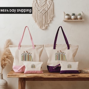 a collection of colorful tote bags and a small makeup bag arranged on a wooden table. The tote bags are pink and purple, while the makeup bag is purple. The table is set against a white wall, and there is a wall hanging above the table. The image also includes text that reads "next day shipping".