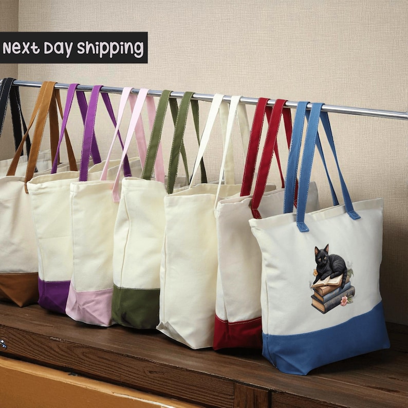 A row of colorful tote bags hanging on a rack, with a sign indicating next day shipping.