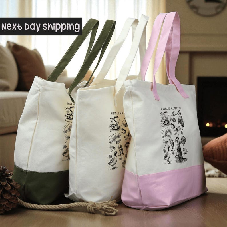 Three tote bags with different colors and designs, including a pink tote bag with a printed illustration of wildlife and plants.